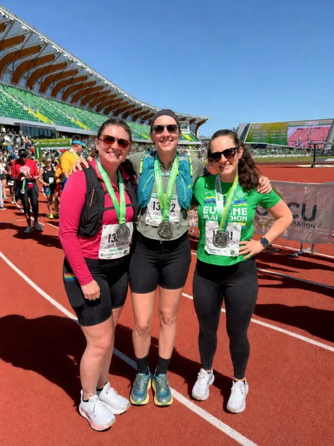 Marin with friends and finisher medals at Hayward Field after the Eugene Marathon